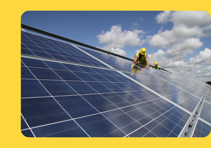 Person on top of solar panels, working on installing them.